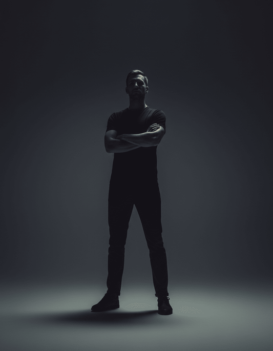 Confident man standing in shadowy light, symbolizing TestoRise men's natural vitality reset